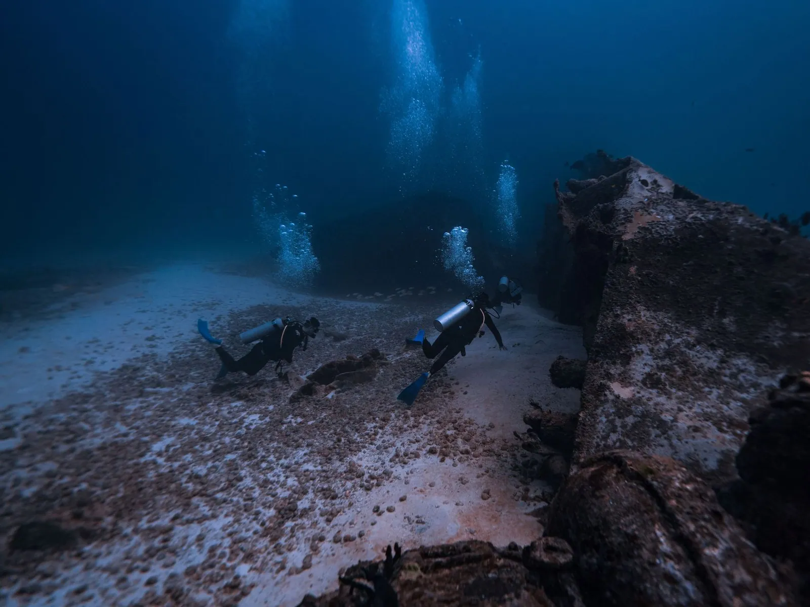 Divemaster guiando um mergulho próximo a um naufrágio