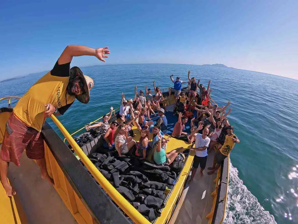 Turma de mergulhadores comemorando a bordo depois do mergulho