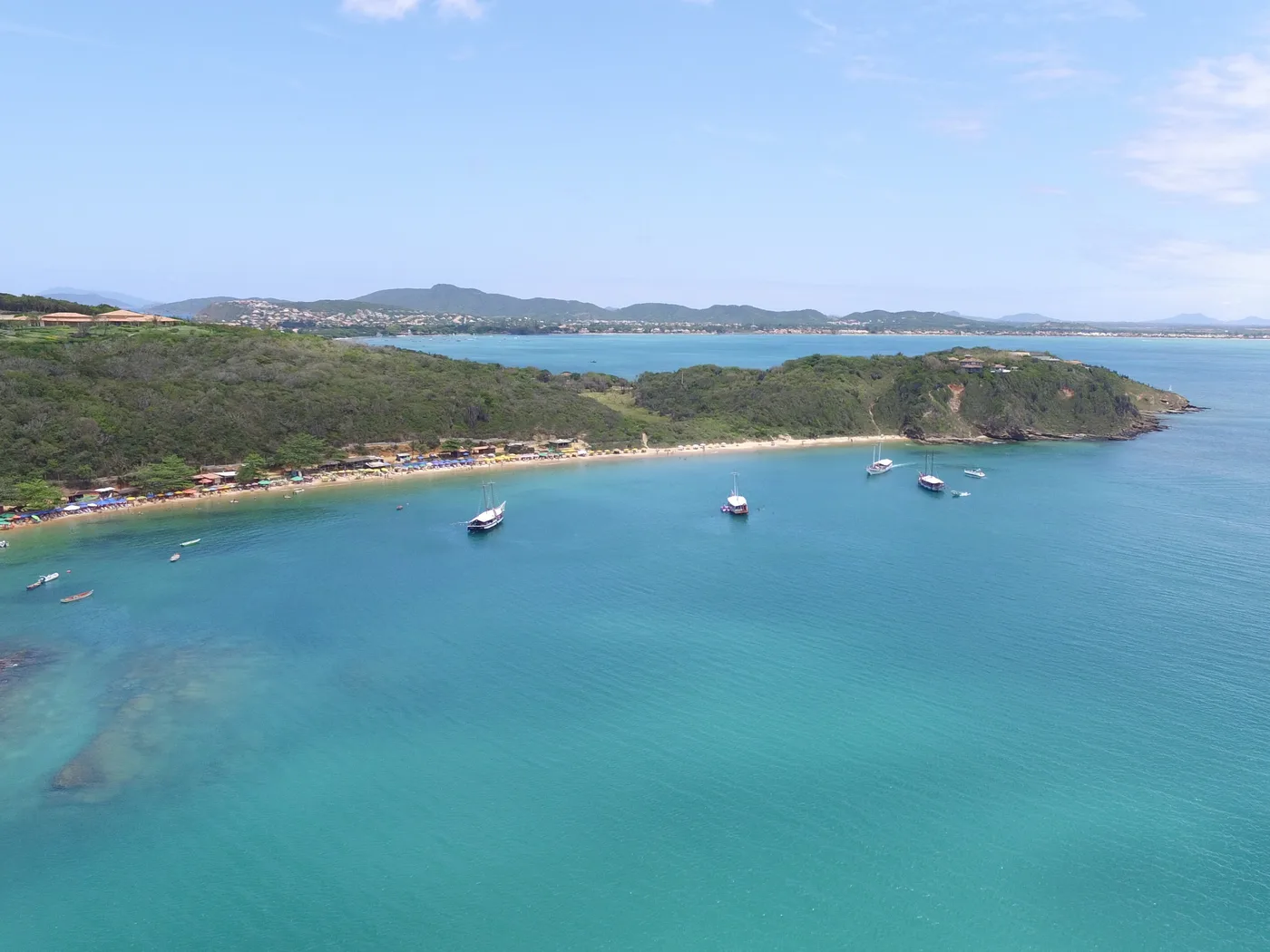 Vista aérea da Praia da Tartaruga, em Búzios, com barcos ancorados na água turquesa