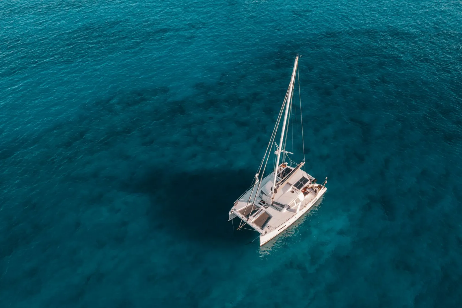 Catamarã navegando em mar aberto de águas azul-turquesa