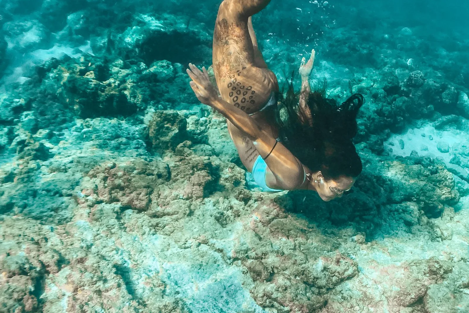 Mergulhador explorando um recife de coral em águas cristalinas