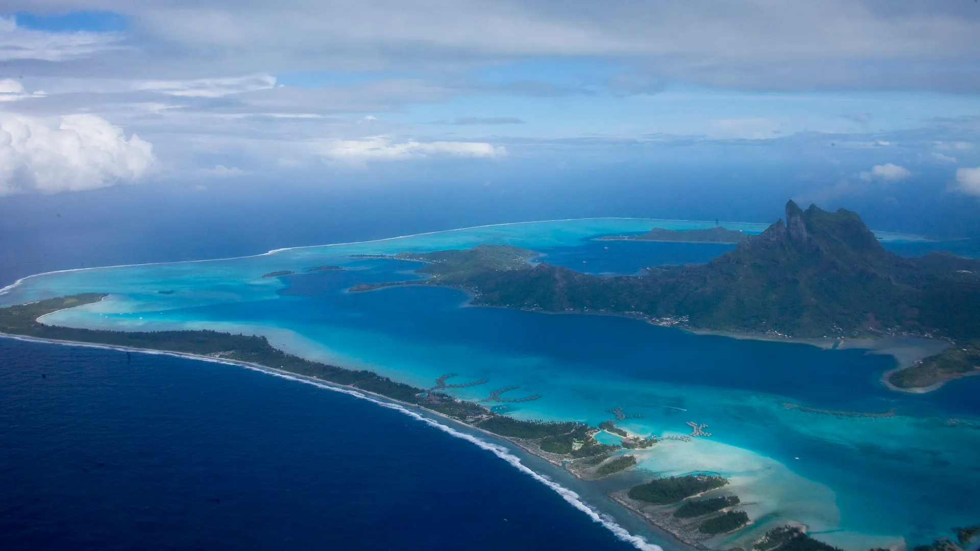 Vista aérea de Bora Bora, com a lagoa, os motus e o Monte Otemanu ao fundo