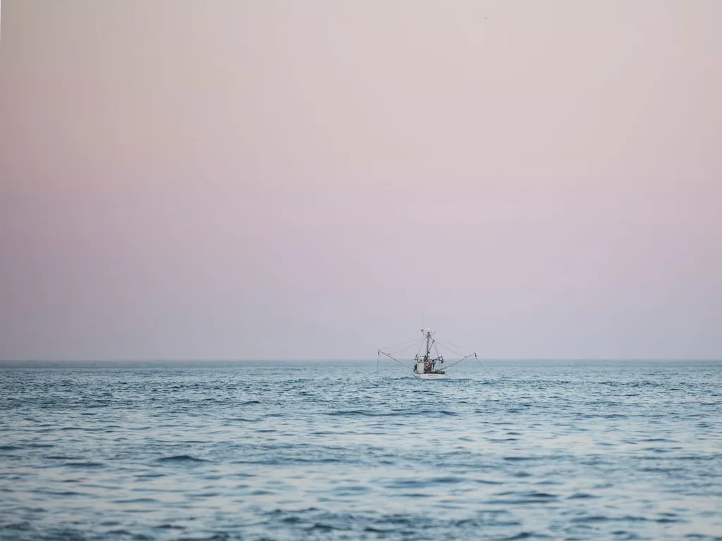 Embarcação isolada em mar aberto ao entardecer