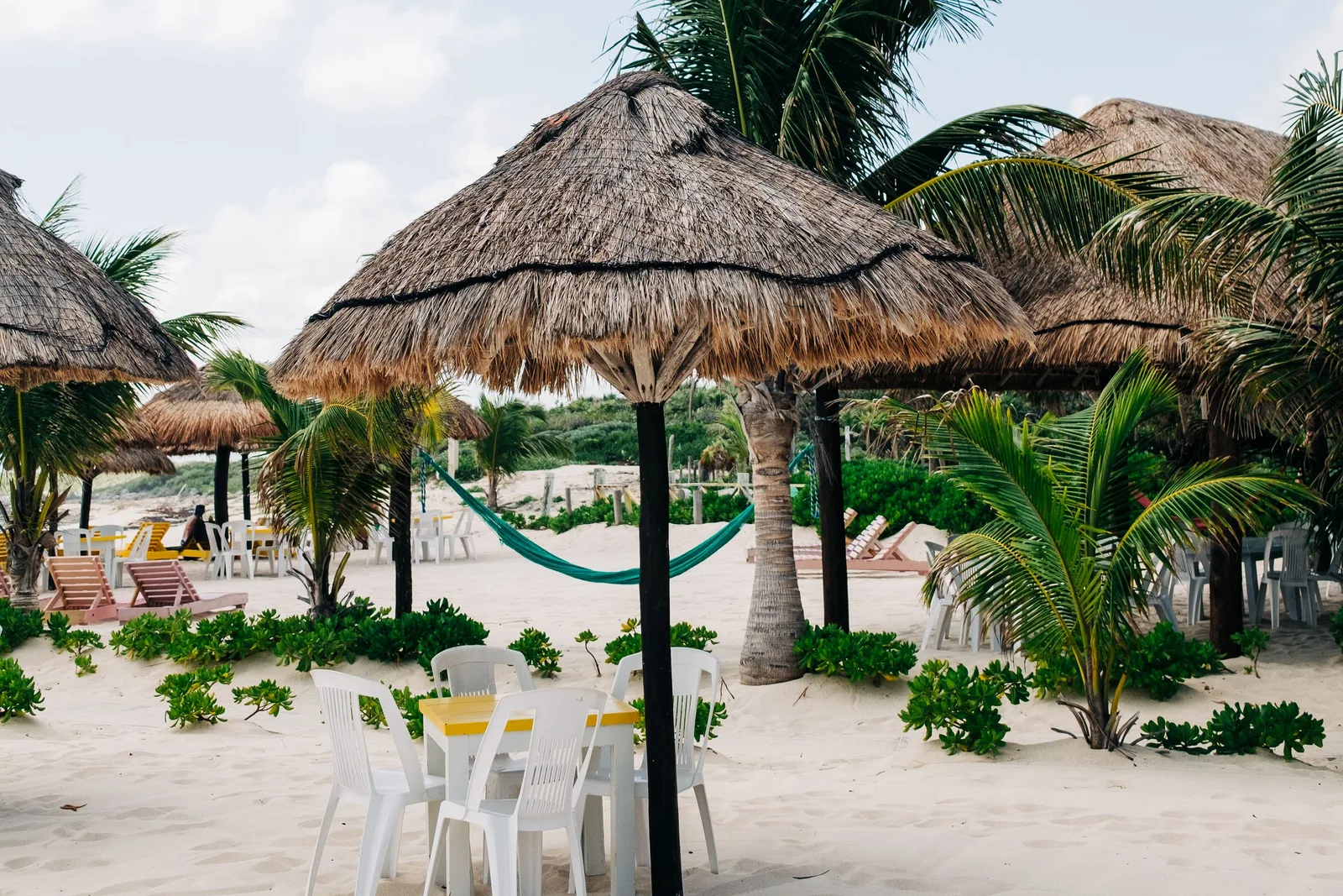 Praia de Cozumel com palapas e coqueiros à beira do mar caribenho