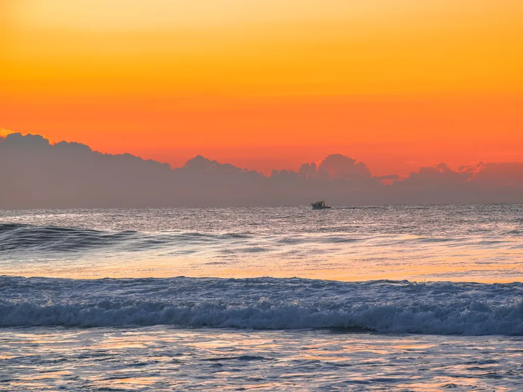 Embarcação de mergulho navegando em mar aberto ao entardecer