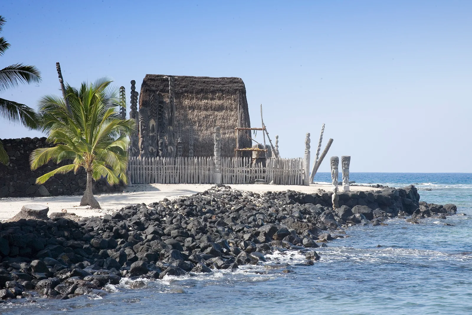 Templo de palha e estátuas de madeira em Puʻuhonua o Hōnaunau, na costa de Kona