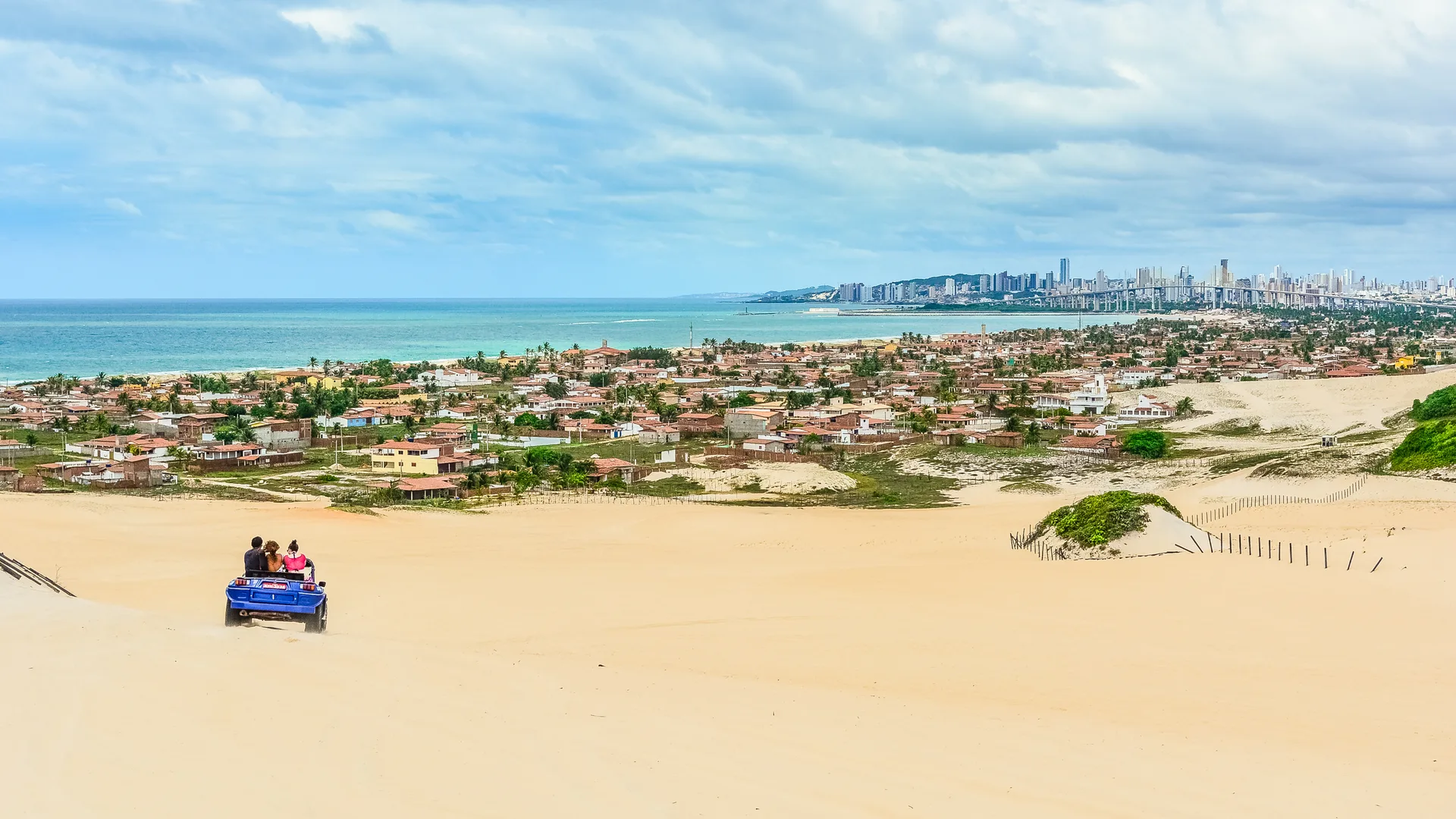Buggy nas dunas de Genipabu, com o mar e a cidade de Natal ao fundo