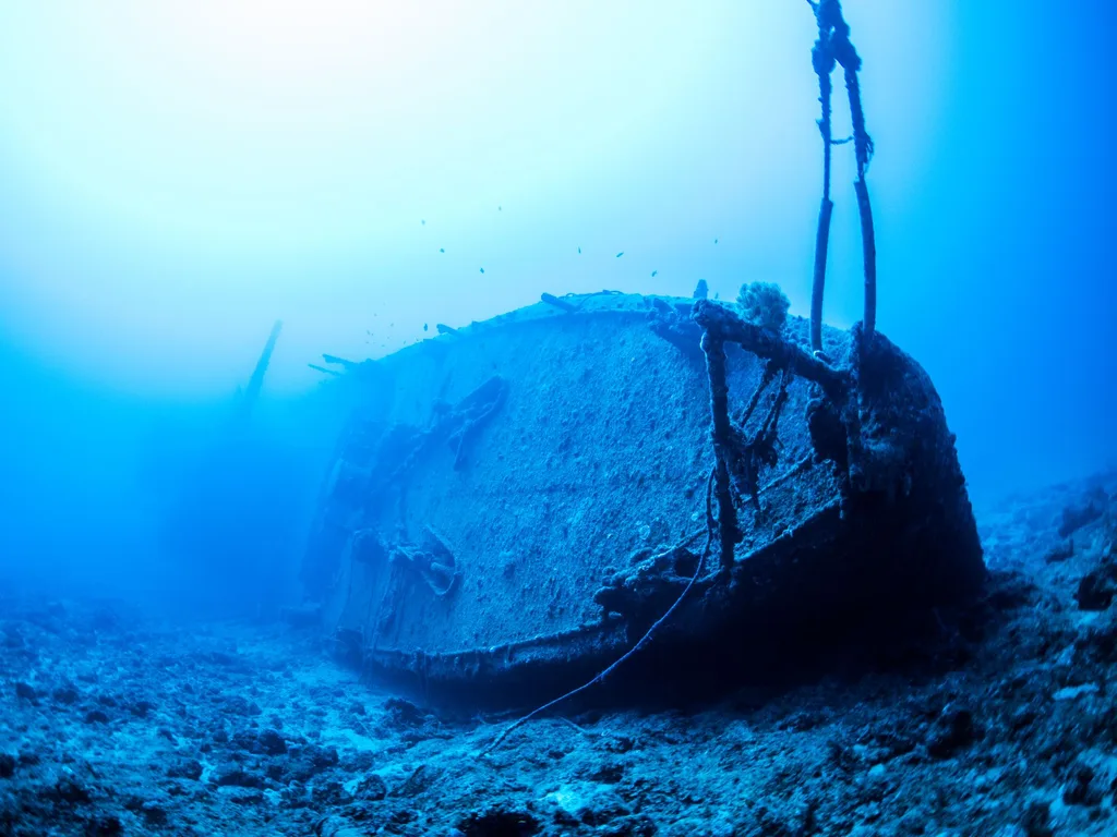 Casco de navio naufragado sobre o fundo do mar em água azul