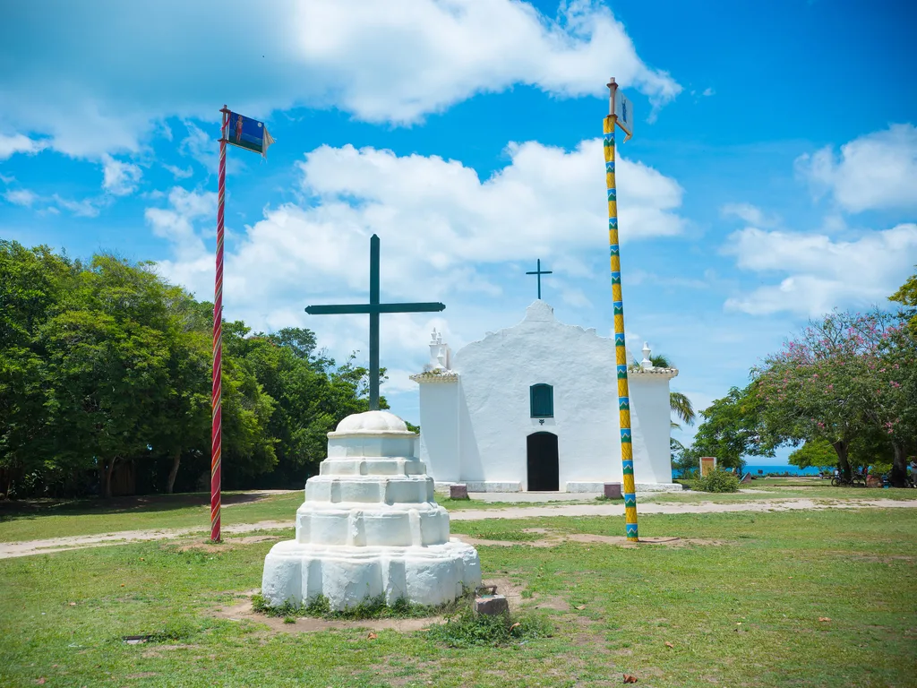 Igreja de São João Batista no Quadrado de Trancoso, com cruz e mastros coloridos